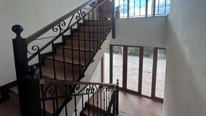 A staircase with ornate black railings leading to an upper floor.