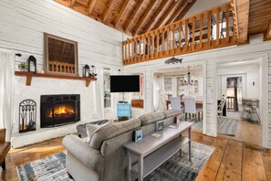 A cozy living room with a fireplace, a television, and a comfortable seating area. - kingisher river cabin (Murphy)