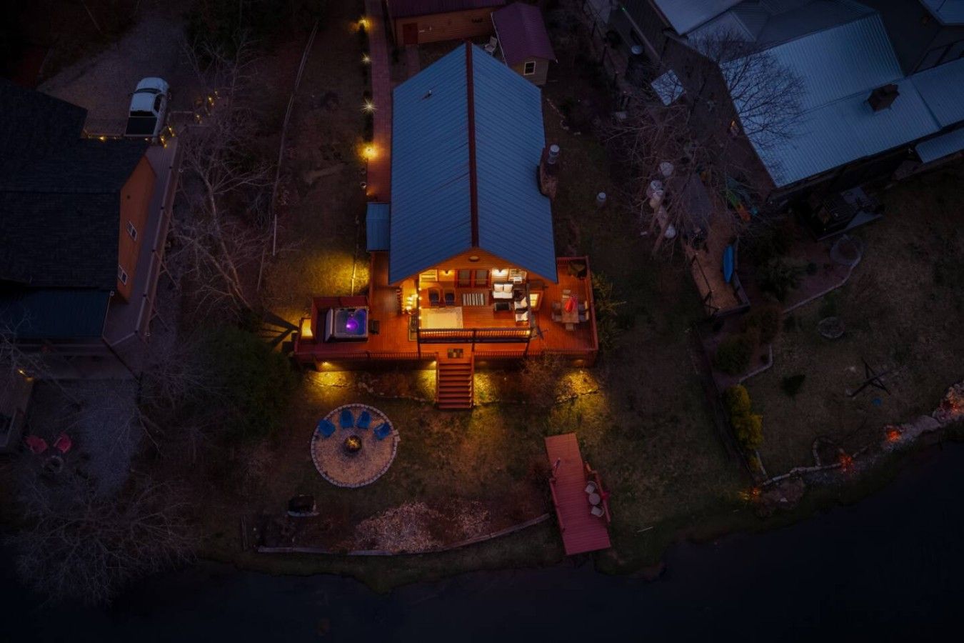 A house with a deck, outdoor seating, and a fire pit.