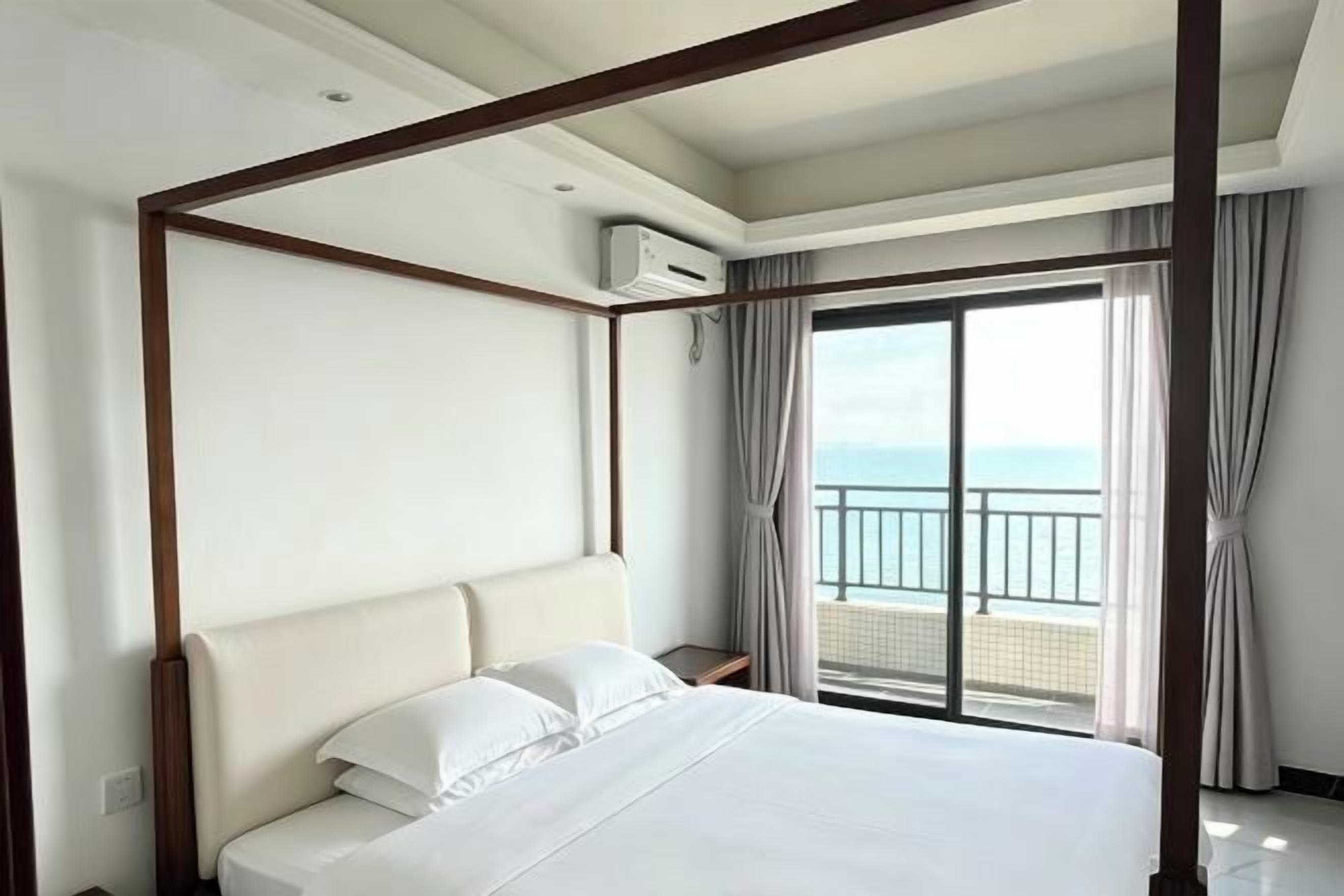 Ein Hotelzimmer mit Himmelbett, Balkon und Blick sowie einer Klimaanlage.