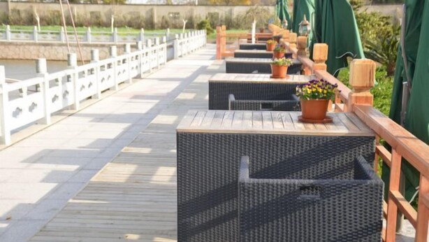 A wooden deck with outdoor seating and potted plants. - Hewu Bay Farmhouse (Shanghai)