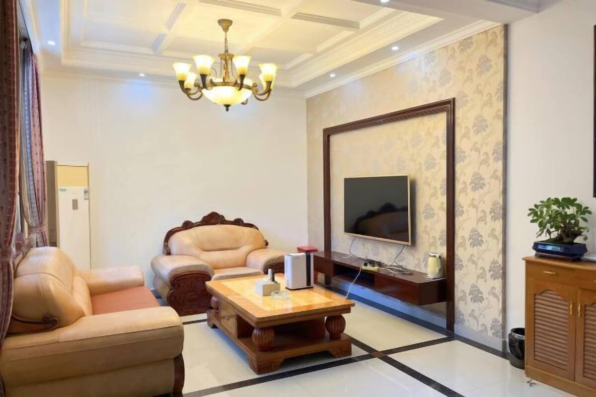 Una sala de estar con sofá, mesa de centro, televisor y candelabro.