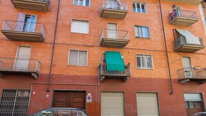 Un edifici residencial de diverses plantes amb balcons, finestres i una porta de garatge.