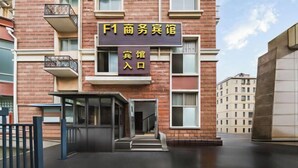 A modern building with a sign reading "F1 商务宾馆" and "宾馆入口" indicating a business hotel entrance. - F1 Business Hotel (Shanghai Xinhua Hospital) (Shanghai)