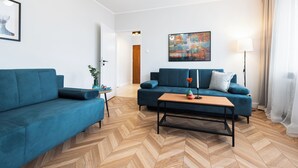 Una sala de estar moderna con dos sofás azules, una mesa de centro de madera y un cuadro en la pared.