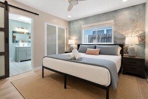 A bedroom with a bed, nightstands, a window, and a view of the outside. - 360 Ocean View Roof Deck, 50 Steps to Beach+AC (Oxnard)