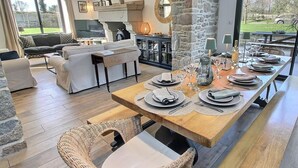 A dining area with a long wooden table set for four, surrounded by wicker chairs. - La Marie Morgane - LEZARDRIEUX (LEZARDRIEUX)