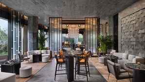 Un intérieur moderne comprenant un coin repas, des canapés et une grande fenêtre.
