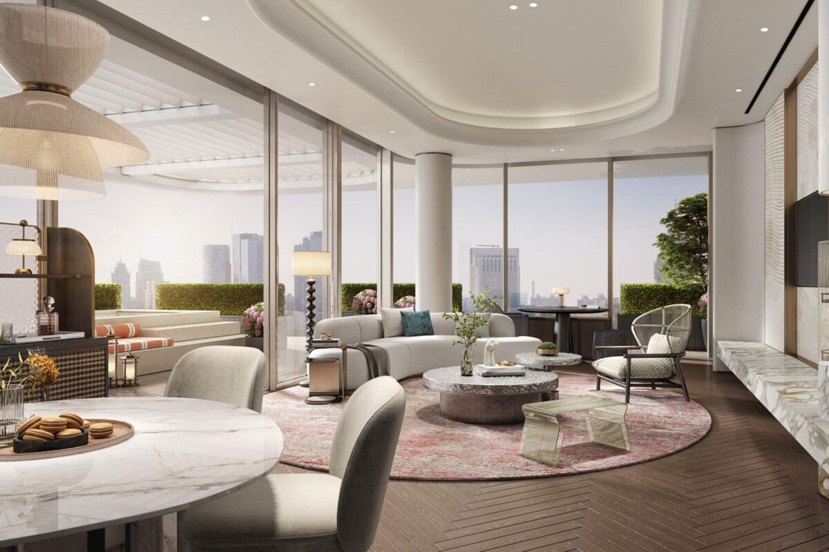 A modern interior with a round marble table, comfortable seating, and a city view.