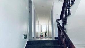 A staircase with a wooden handrail leading to a landing. - Donghai Fishing Village Ganhai Renjia Guest House (Shengsi)