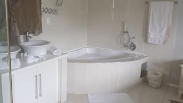 Un baño con bañera, lavamanos y ducha.