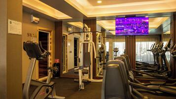 A gym with treadmills, elliptical machines, and weight machines.