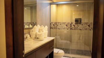 Ein modernes Badezimmer mit einer Glasdusche, einem Marmorwaschtisch und einer Toilette.