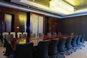 A conference room with a long table, chairs, and a chandelier. - Qingcheng Hotel (Qinghe)