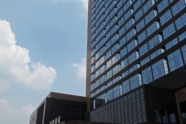 A tall building with a modern glass facade and a clear sky. - Qingcheng Hotel (Qinghe)