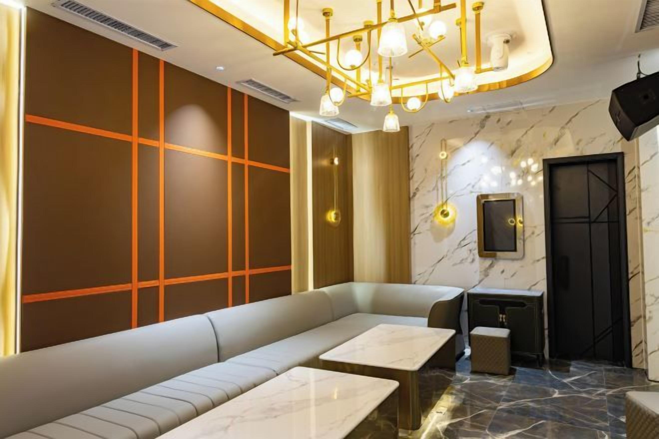 Un intérieur moderne avec un coin salon, un sol en marbre et un téléviseur fixé au mur.