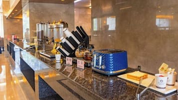 Ein Frühstücksbereich eines Hotels mit einer Marmorplatte, einem blauen Toaster und einer Kaffeemaschine.