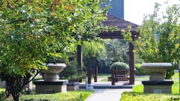 A pathway leading to a traditional Japanese-style structure with stone lanterns and a well-maintained garden.