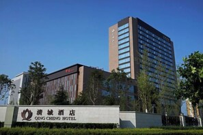 Un hotel con un cartel llamativo, un edificio alto con muchas ventanas y un cielo azul despejado.