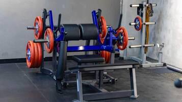 A gym with weightlifting equipment including a bench press and barbells.