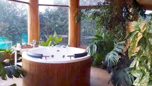 A wooden spa tub with a view of a garden. - cabañasmapulauquen (Villarrica)