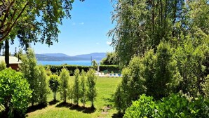 A lush garden with a clear view of a lake and mountains in the distance. - cabañasmapulauquen (Villarrica)