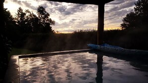 A hot tub under a covered area with a sunset view. - cabañasmapulauquen (Villarrica)