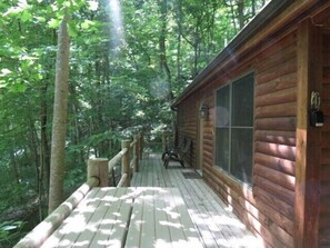 Eine Holzterrasse mit Blick auf einen Wald.