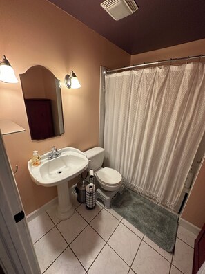 Ein Badezimmer mit Waschbecken, Toilette und Duschvorhang.