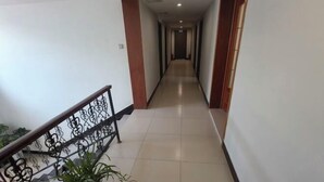 A long, narrow hallway with a tiled floor and a metal railing on one side. - Shijiazhuang Yiguang Hotel (Shijiazhuang)