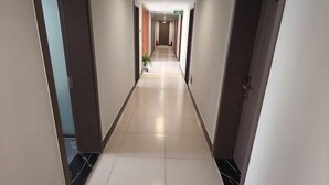 A long, narrow hallway with a tiled floor and doors on both sides. - Shijiazhuang Yiguang Hotel (Shijiazhuang)