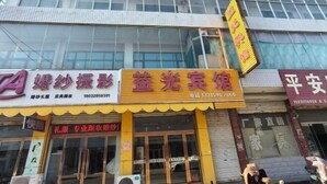 A building with multiple storefronts, including a visible sign for a photography studio and a hotel. - Shijiazhuang Yiguang Hotel (Shijiazhuang)