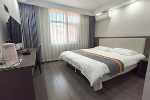 A hotel room with a bed, a desk, a chair, and a window with curtains. - Shijiazhuang Yiguang Hotel (Shijiazhuang)