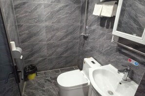 A bathroom with a toilet, sink, and mirror. - Shijiazhuang Yiguang Hotel (Shijiazhuang)