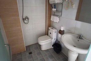 A small bathroom with a toilet, sink, and a towel rack. - Shijiazhuang Yiguang Hotel (Shijiazhuang)