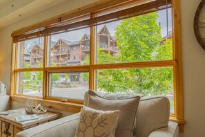 A room with a large window overlooking a building with multiple balconies.