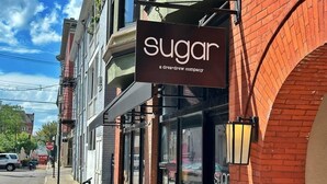 A storefront with a sign reading "sugar a dream+drew company" on a brick building with large windows. - Boho Studio Loft in OTR Near Downtown Cincy (Cincinnati)