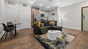 A modern apartment with a living room, dining area, and kitchen.