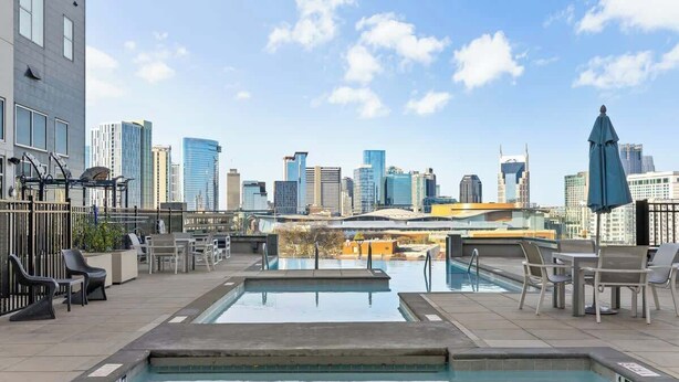 A rooftop pool with city views, lounge chairs, and a blue umbrella. - 2 King Suites Walk to Broadway & Gulch (Nashville)