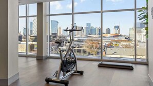 A spacious gym with a large window offering a city view.