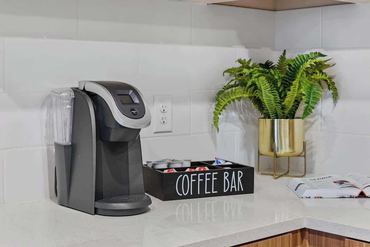 Una cucina moderna con una macchina da caffè, un angolo caffetteria e una pianta in vaso.