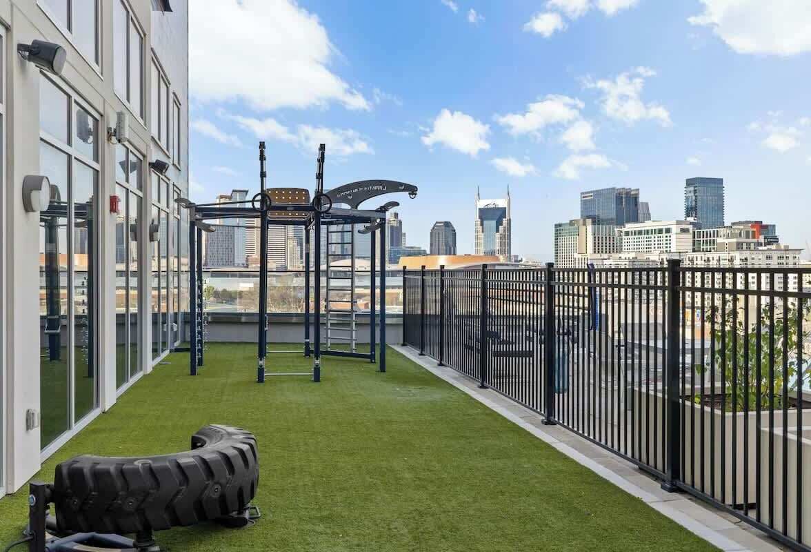 A rooftop gym with exercise equipment and a city view.