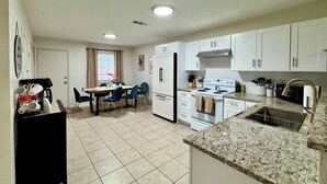 A modern kitchen with white cabinets, a granite countertop, a stove, and a sink. - Swim, Hike, Explore & Relax just minutes from lakes-beaches, nature & Ft. Worth! (Azle)