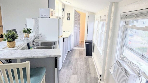 A narrow kitchen with a built-in stove, a sink, and a window. - 1 BD 7 minutes to 7 mile beach. Sleeps 3 and pet freindly<br>- FREE parking<br>- queen bed and futon<br>- fast wifi<br>-smart TV<br>- BBQ, Picnic table and fire pit (Old orchard beach)