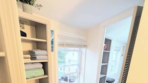 A narrow hallway with a white storage unit on the left, a window with blinds, and a door leading to another room. - 1 BD 7 minutes to 7 mile beach. Sleeps 3 and pet freindly<br>- FREE parking<br>- queen bed and futon<br>- fast wifi<br>-smart TV<br>- BBQ, Picnic table and fire pit (Old orchard beach)