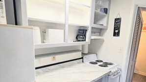 A compact kitchen with a built-in stove, a refrigerator, and a coffee maker on the countertop. - 1 BD 7 minutes to 7 mile beach. Sleeps 3 and pet freindly<br>- FREE parking<br>- queen bed and futon<br>- fast wifi<br>-smart TV<br>- BBQ, Picnic table and fire pit (Old orchard beach)