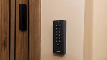 A door with a modern keypad lock and a wooden panel.