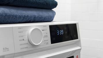 A front view of a washing machine with a digital display, a dial, and a label indicating a 6 kg capacity.