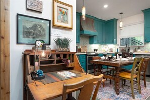 A dining area with a wooden table, chairs, a clock, and a framed picture on the wall. - Boho Buffalo: Luxe Texas Hideaway in The Gap (Buffalo Gap)