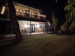 A two-story house with a balcony, a dining area, and a staircase leading to the upper level. - Boho Buffalo: Luxe Texas Hideaway in The Gap (Buffalo Gap)
